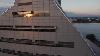 RIGA, LATVIA - 25 Temmuz 2020: Arkaplanda Riga şehri ile birlikte Letonya Ulusal Kütüphanesi (NLL). 2014 yılında, mimar Gunnar Birkerts tarafından tasarlanmıştır..