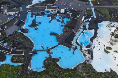 Parlak mavi suları, modern tesisleri ve engebeli lav tarlaları olan jeotermal kaplıca. Lagünden buhar yükseliyor, yollar ve yakınlarda park yeri var..