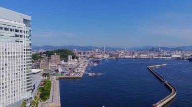 Japonya 'nın Hiroşima şehrinin havadan görünüşü, teknelerin, kentsel binaların, yeşil alanların ve hareketli dağların bulunduğu bir limanı gösteriyor..