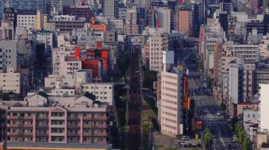 Osaka, Japonya 'nın havadan görünüşü, gökdelenler, çeşitli mimari ve yoğun şehir silueti boyunca yavaş bir tavayla canlı bir tabela sergileniyor..