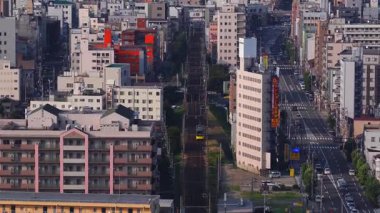 Japonya 'nın Osaka kentinin hava görüntüsü, yüksek binaları, renkli tabelaları, aktif caddeleri ve devam eden inşaat faaliyetlerini vurgulayan vinçleri gösteriyor..