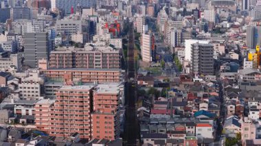 Japonya 'nın Osaka kentinin havadan görünüşü, Tsutenkaku Kulesi, modern yüksek binalar, ve gökyüzü altında yavaş çekim yapan geleneksel yapılar..