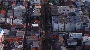 Japonya, Osaka 'nın havadan görünüşü, kentsel yoğunluğu, demiryolu hattı, modern ve geleneksel binalar ve arka planda kubbeli bir yapı..