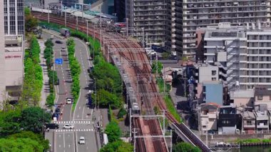 Japonya 'nın Osaka kentinin havadan görünüşü, yüksek binaları, inşaat vinçlerini ve şehir manzarası boyunca hareket eden trenleri gösteriyor..