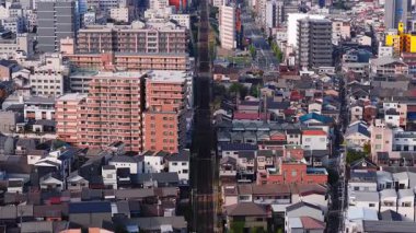 Osaka, Japonya 'nın havadan görünüşü, aydınlık gün ışığında modern yükseliş, yerleşim alanları, sokaklar ve kavşakları yavaş ve sabit bir şekilde gösteriyor..