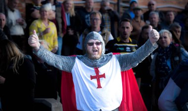 YORK, İngiltere - Eylül, 2018. İngiliz futbolu ya da rugby taraftarı bir spor müsabakasının tribünlerinde yüksek sesle tezahürat yapan zincirli bir şövalye savaşçısı gibi giyinmiş.