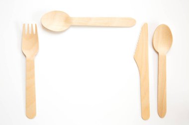 Sürdürülebilir ve geri dönüşümlü ahşap çatal bıçak, çatal ve kaşık yemek yer ayarı ve kopya alanı ile beyaz bir arka plan ayarlamak da dahil olmak üzere, bir düz yatıyordu