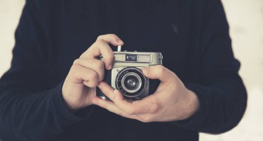 Bir midsection bir retro veya eski moda 35 mm kamera tutarak ederken objektif odaklama bir erkek fotoğrafçı