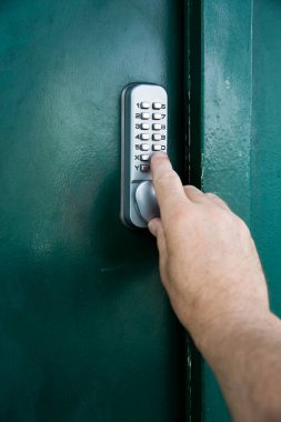 Harflerin ve numaraların yakın plan güvenlik şifresi insan eliyle şifrelenmiş. Kopya alanı olan güvenli bir yere girmek için bir koda basılıyor.
