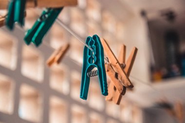 Çamaşırhanede çamaşır mandalları var. Giysi askısı bir ipte