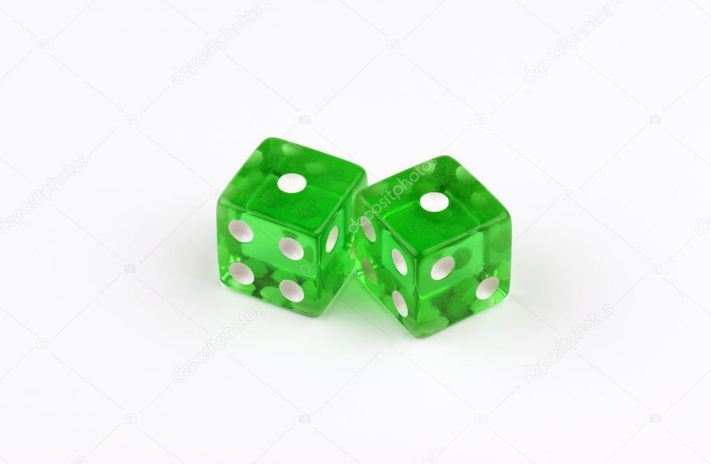 A pair of green, translucent gaming dice on a white background with their spots showing a pair of ones, or unlucky snake eyes as in a losing game of craps in a casino.