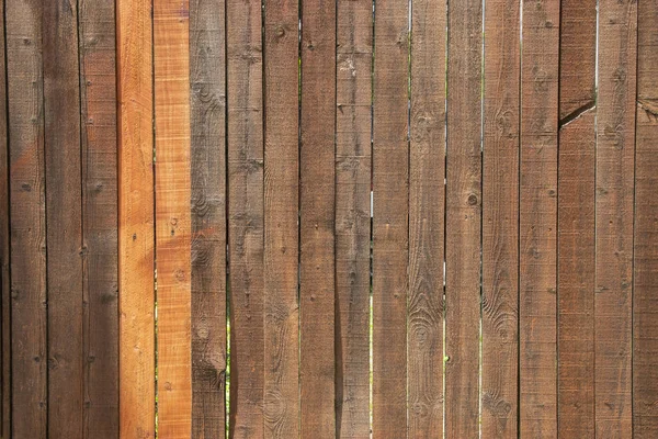 Dark stained wood fence with two lighter slats — Stock Photo, Image