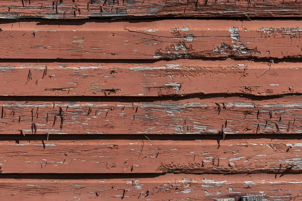 Vieux mur de grange avec de la peinture rouge décolorée et pelante — Photo