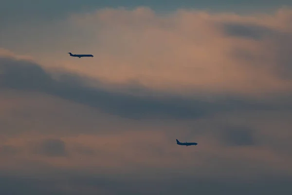 Ett Par Passagerare Jetplan Flyger Genom Molnig Mulen Himmel Som Royaltyfria Stockfoton