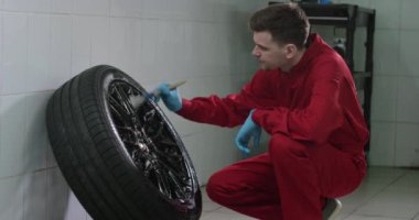 Araba yıkama fırçası ile tekerlek dikkatlice yıkıyor slowmotion