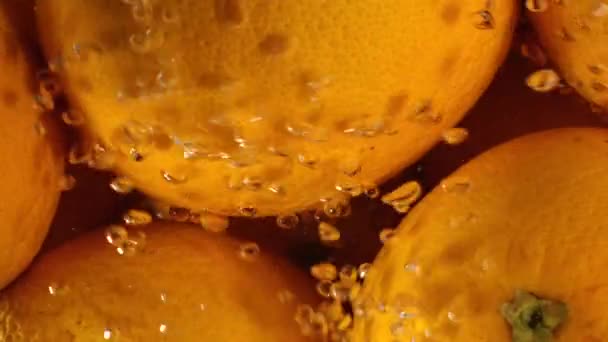 Orange Tropfen unter Wasser auf schwarzem Hintergrund. frische Orangenfrüchte tauchen ein und spritzen Wasser. Wasserluftblasen — Stockvideo