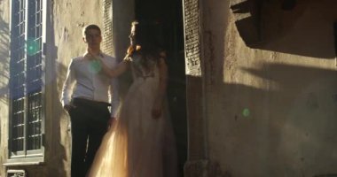 Bir genç çift kucak ve öpücük bir duvarın önünde dururken