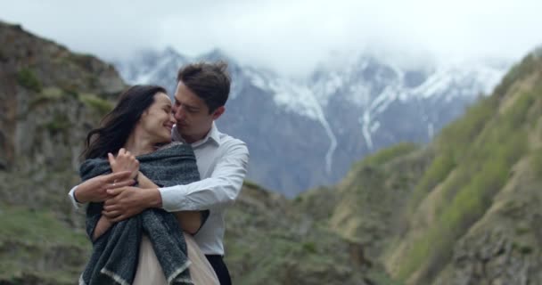 Pareja romántica abraza en el borde de la montaña — Vídeos de Stock