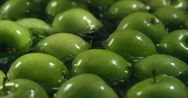 Su ile yıkandıktan taze yeşil elma. Meyve yıkama.