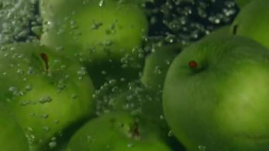 Siyah arka plan, süper ağır çekim suda yeşil elma düşmek