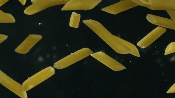 Penne pasta dropping in boiling water — Stock Video