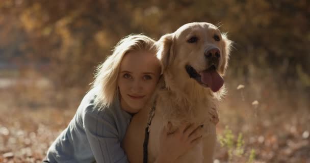 Mladá žena hraje s labrador zlatý retrívr psa v parku, pomalý pohyb — Stock video