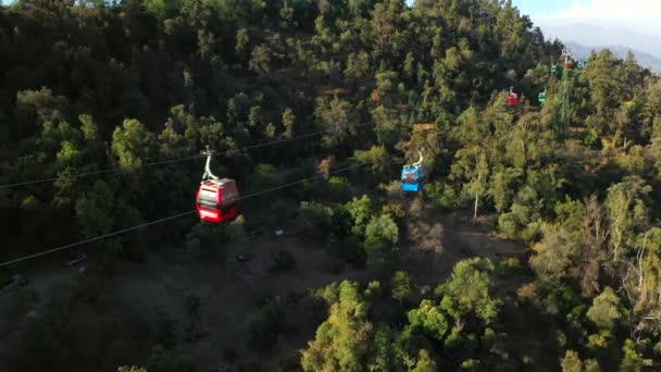 Widok z lotu ptaka kolorowych kolejek linowych poruszających się na szczycie Cerro Cristobal w Santiago, Chile. — Wideo stockowe