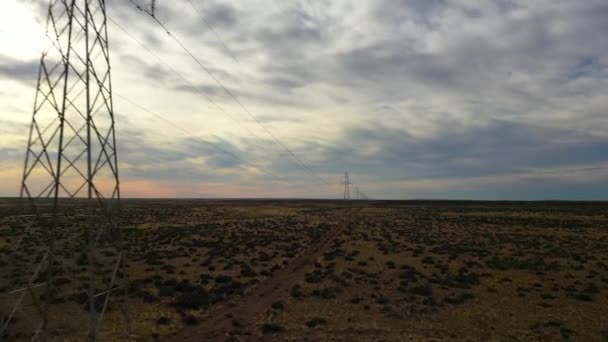 Vista aérea de drones de líneas eléctricas y eléctricas de alto voltaje al atardecer. Paisaje pampeano en Patagonia, Argentina, Sudamérica — Vídeos de Stock