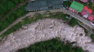 Peru, Güney Amerika 'da Machu Picchu yakınlarındaki Aguas Calientes köyünün ve Urubamba nehrinin havadan drone görünümü.