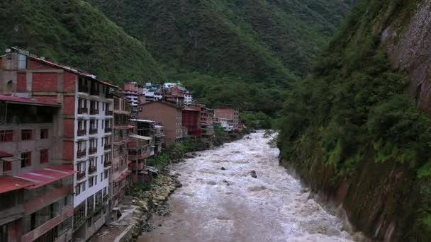 Peru, Güney Amerika 'da Machu Picchu yakınlarındaki Aguas Calientes köyünün ve Urubamba nehrinin havadan drone görünümü. — Stok video