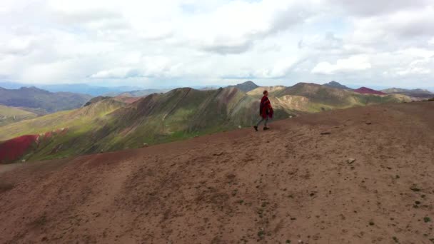 Antenn drönare skjuten av en flicka i en autentisk regnbåge poncho vandra på en Bergs sluttning. Röd dal av Andes färgat berg, Peru — Stockvideo