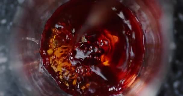 Top närbild syn på hälla röd alkohol till glaset i slowmotion, bartender på jobbet. Närbild skott på 6k röd kamera. — Stockvideo