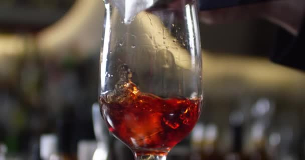 Närbild av isbitar som faller i glas med alkoholhaltiga cocktail. Närbild skott på 6k röd kamera. — Stockvideo