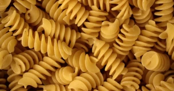 Droge Italiaanse Fusilli pasta roterende in slow motion. Extreme close-up bovenaanzicht, neergeschoten op de rode 6k-camera — Stockvideo