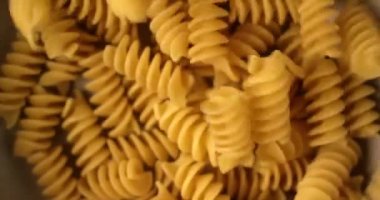 Fusilli İtalyan makarna düşen ve yavaş hareket dönen. Kırmızı 6k kamerada çekilen üst görünümü ne kadar yakın