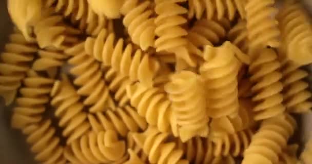 Fusilli italiensk pasta faller och roterar i slow motion. Extreme närbild uppifrån, skjuten på röd 6k kamera — Stockvideo