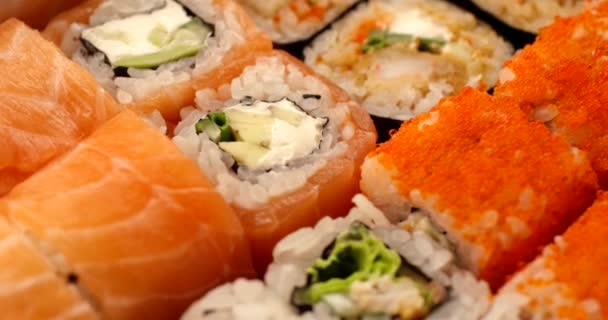 Rollos de sushi fresco girando en cámara lenta. Vista de cerca extrema, filmada con la cámara RED 6K — Vídeo de stock