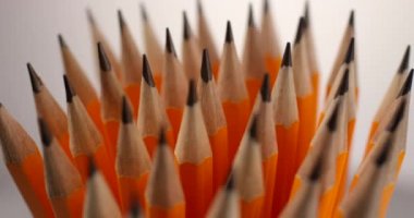 Sarı kaplamalı kalemler ağır çekimde dönüyor. Yakın çekim, kırmızı 6K kamera.