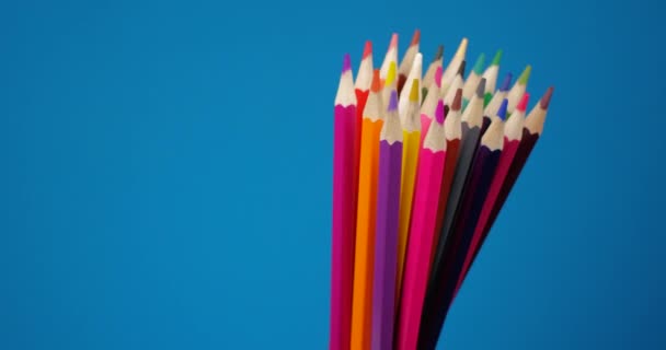 Ensemble de crayons multicolores tournant sur un écran bleu, fond chromatique. Vue de près extrême, prise de vue sur caméra 6K ROUGE — Video