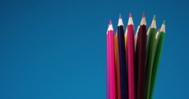 Conjunto de lápices multicolores girando sobre una pantalla azul, fondo cromado. Vista de cerca extrema, filmada con la cámara RED 6K — Vídeo de stock