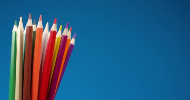 Conjunto de lápices multicolores girando sobre una pantalla azul, fondo cromado. Vista de cerca extrema, filmada con la cámara RED 6K — Vídeos de Stock