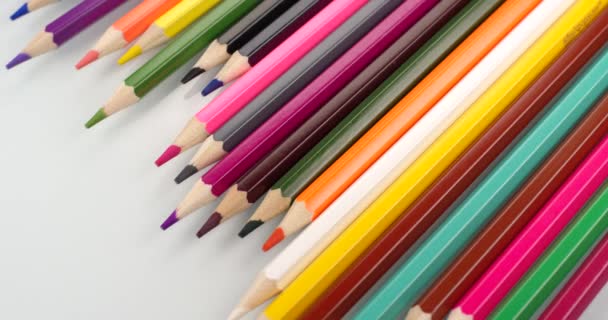 Färgade blyertspennor visas på vit bakgrund. Närbild Visa, skjuten på röd 6k kamera — Stockvideo