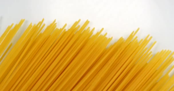 Спагетти появляются на белом фоне. Закрыть макровид, снятый на камеру RED 6K — стоковое видео