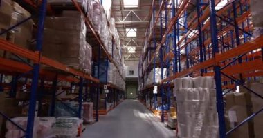 Kamera büyük bir modern lojistik deposunda paletve kutuları ile raflar arasında hareket eder. 6k Kırmızı kamerada çekilmiş.