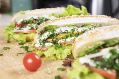 hızlı abur cubur lezzetli sosisli sandviç küçük kiraz domates yakın masada sulu yeşil ve Barbekü soslu