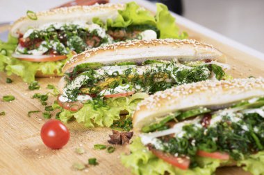 hızlı abur cubur lezzetli sosisli sandviç küçük kiraz domates yakın masada sulu yeşil ve Barbekü soslu