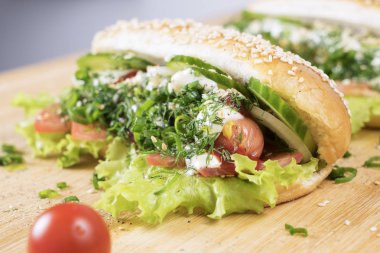 hızlı abur cubur lezzetli sosisli sandviç küçük kiraz domates yakın masada sulu yeşil ve Barbekü soslu