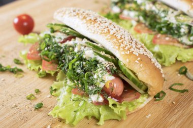 hızlı abur cubur lezzetli sosisli sandviç küçük kiraz domates yakın masada sulu yeşil ve Barbekü soslu