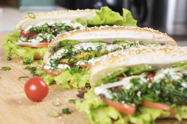 hızlı abur cubur lezzetli sosisli sandviç küçük kiraz domates yakın masada sulu yeşil ve Barbekü soslu