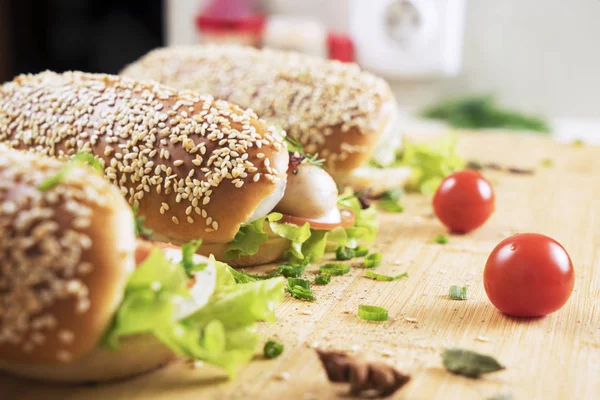 hızlı abur cubur lezzetli sosisli sandviç küçük kiraz domates yakın masada sulu yeşil ve Barbekü soslu